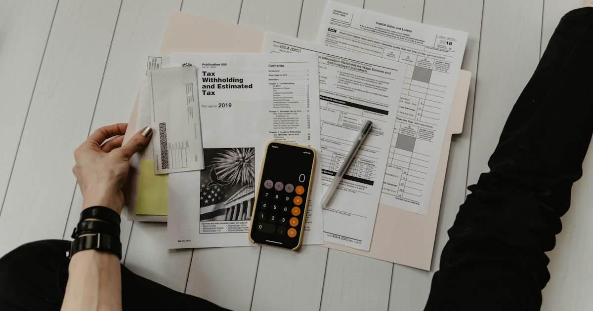 Accountant reviewing financial documents and statements with a calculator at an office desk